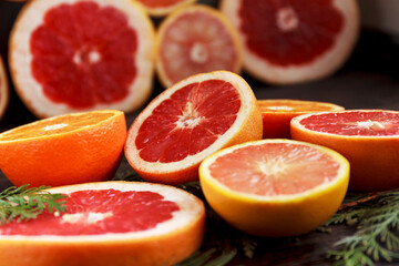 Naklejka na ściany i meble Ripe juicy grapefruit and oranges lie on a dark table
