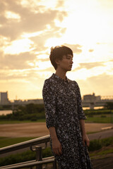 夕日 河川敷 ショートヘアの女性