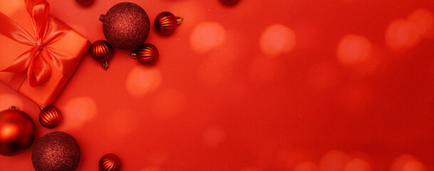 Christmas decorative composition with red shiny Christmas balls and gift on red Crhistmas lights...