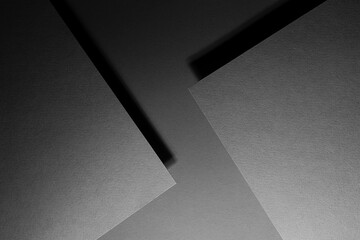 Grey carbon abstract geometric background with soar rectangle surfaces of sheet with corners in hard light, black shadows - monochrome style backdrop in elegant simple modern minimal style, top view.