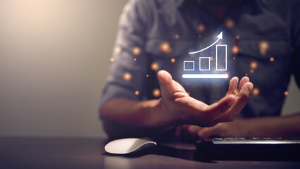 Man's hand holding the glowing graphic icon, Business enterprise development, and industrial growth concept.