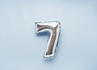 Silber balloon number 7 on light blue background for your New Year of birthday desing