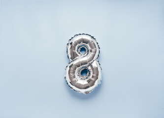 Silber balloon number 8 on light blue background for your New Year of birthday desing