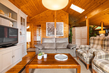 Beautiful interior of cozy living room with sofa and armchairs in a wooden house. Life in a village