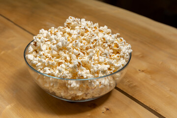Popcorns in a glass bowl on wooden table