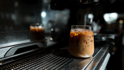 Ice coffee on a table with cream being poured into it showing the texture