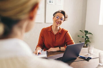 Happy hiring manager interviewing a job candidate in her office - Powered by Adobe