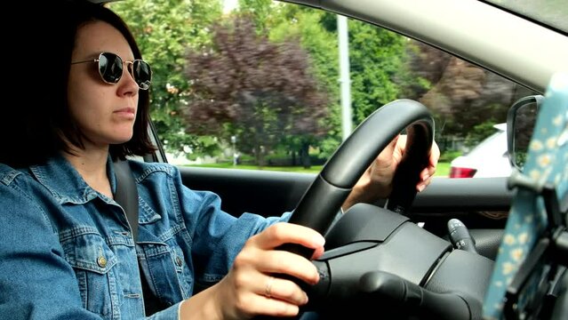 woman in sunglasses and jeans coat driving the car
