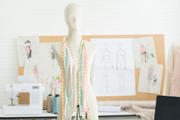 Obraz premium Dummy mannequin with hanging measuring tape with fashion design background in the tailor shop. garment, design, fashion, dressmaking concept