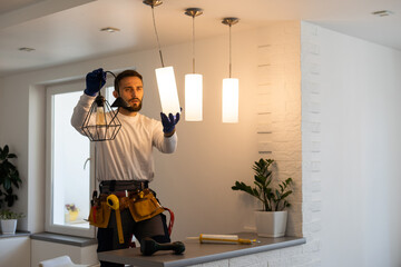Electrician mounting ceiling lamp - installing the wires.