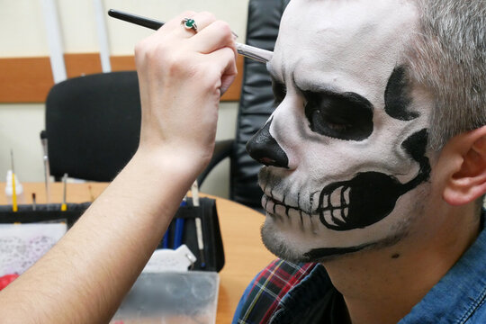 makeup for halloween preparation, man with traditional mexican halloween makeup, caballero celebrating day of the dead, face art, body art