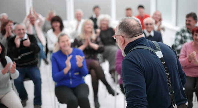 Mature caucasian man gives a speech in meeting in modern open office