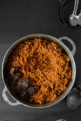 Jollof rice and fried beef in a cast iron pot, Nigerian party jollof rice, smoky jollof, red rice