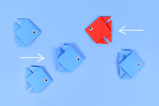 Red Paper Fish Swimming Swimming Against The Current In Opposite Direction Of Blue Fish