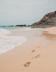Fototapeta na wymiar Footprints in sand, minimal beach aesthetics