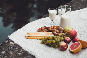 Healthy ecological, organic diet food, milk glasses, sausage, pretzel, apple, grapefruit on blanket...