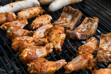Marinated raw meat just put on the barbecue, chicken, ribs and white sausage