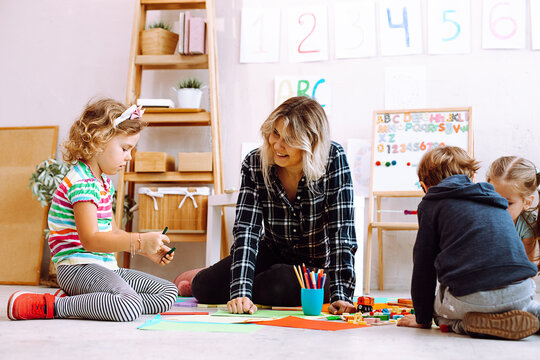 Female Psychiatrist Teacher Play With Children, Make Crafts, Handmade Toys And Paint In Mental Health Development Center