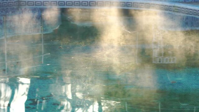 Water in a swimming pool evaporates in the warm morning light