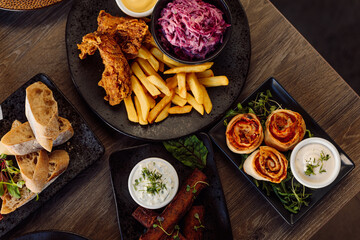 Ciabatta plate, vegetables on plate and roasted grill chicken, french fries, beet root salad, meat rolls. Table layout