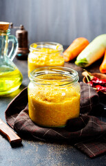 Delicious squash caviar in a jar on the table. Homemade caviar with zucchini, garlic, carrots, tomato sauce. Vegan cuisine.