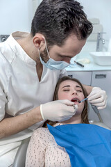 A portrait of a dentist examining female mouth