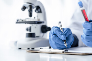 Laboratory and science experiments, chemical hand taking a blood sample tube from a rack analysis lab test in laboratory.