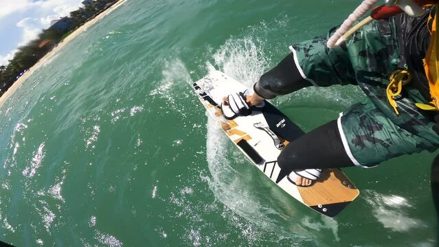 POV of a kite surfing doing acrobatic tricks on tropical ocean, vertical video