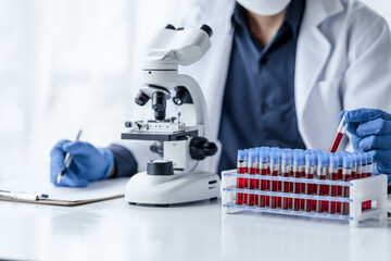 Laboratory and science experiments, chemical hand taking a blood sample tube from a rack analysis...