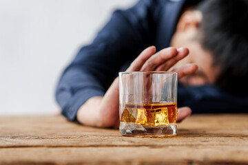 Sad depressed addicted drunk guy, Alone asian man drinker alcoholic sitting at bar counter with glass drinking whiskey. Say no.