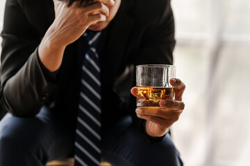 Sad depressed addicted drunk guy, Alone asian man drinker alcoholic sitting at bar counter with glass drinking whiskey.