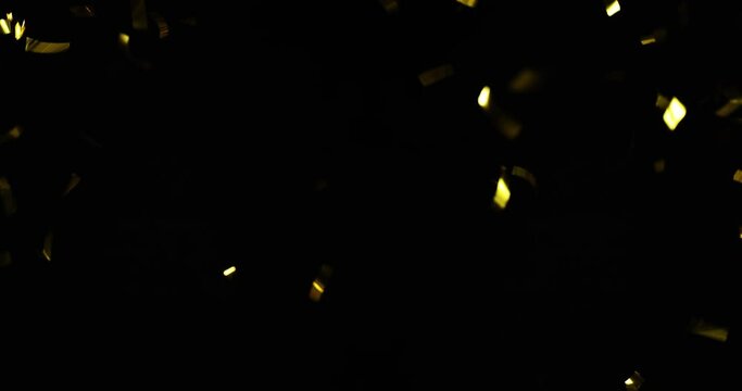 Falling foil confetti with gold glitter on a black background.