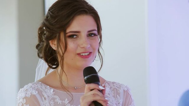 Portrait of beautiful young newlyweds talking to the microphone. Happy moment