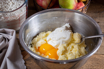 Cornish apple pie step by step, step 3 - adding sour cream and egg yolks to the dough, horizontal,...