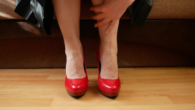Female feet and heels, woman's lags get tied of shoes with high hill, woman after party,