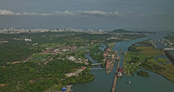Panama City Aerial v38 descending flyover miraflores lake capturing cargo ships transiting at locks canal with cityscape in distance background along skyline - Shot with Mavic 3 Cine - March 2022