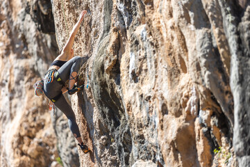 The sports girl is engaged in rock climbing