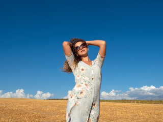 Sensual woman in summer dress standing in field