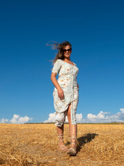 Content female walking in sunny golden field