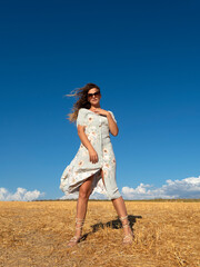Fototapeta na wymiar Carefree woman in summer dress in field