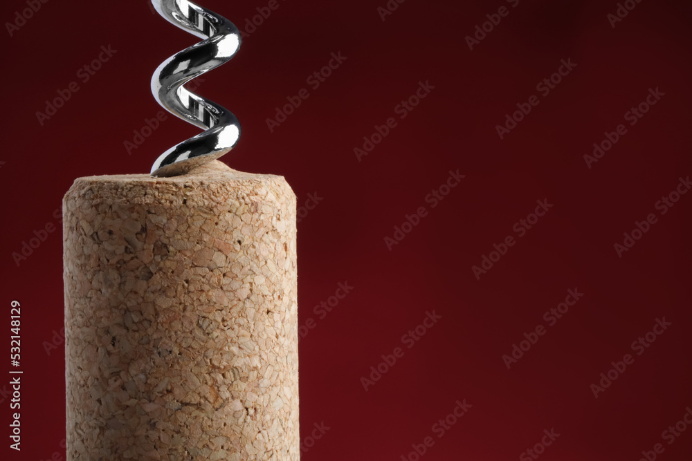 Canvas Prints Corkscrew with wine cork on dark red background, closeup. Space for text