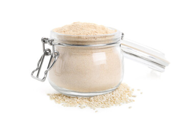Glass jar of sesame flour isolated on white