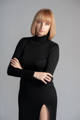 Beautiful blonde businesswoman portrait in black dress on background