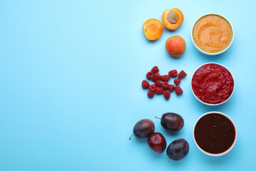 Different puree in bowls and fresh ingredients on light blue background, flat lay. Space for text