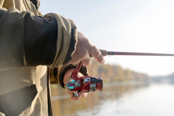 fisherman spins a reel on a spinning rod