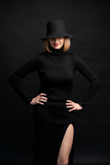 Fototapeta na wymiar Woman in black dress and hat on background