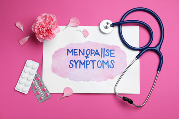 Sheet of paper with words Menopause Symptoms, stethoscope, carnation flower and pills on pink...