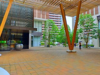 晴れた日の平日の朝の木が植えられている駅前広場の風景（コピースペースあり） © たあきん