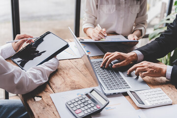 Young colleagues discussing business and price chart analyzes business people on the table great in modern coworking office teamwork concept. Calculate personal tax for customers