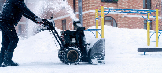 a snow plow removes snow on the playground